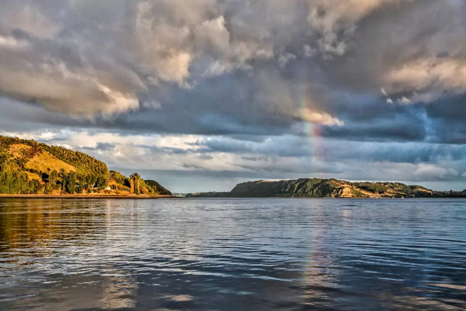 Rainbow over the water and green headlands of Chiloé Island, Chile